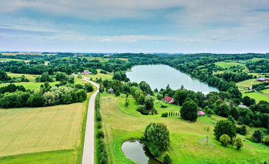 Aerial view of cultural landscape in Lithuania with well-kept meadows around small lake