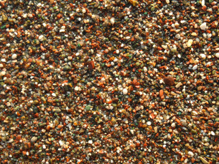 Natural background of wet small gems and pebbles. Sea beach. Leisure and travel.       