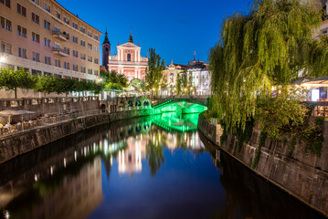 Fototapeta na wymiar Historical city center of Ljubljana, the capital of Slovenia with an old bridge and a reflection in the Ljubljanica river at night