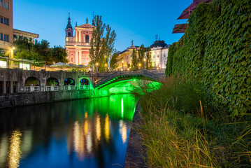 Fototapeta na wymiar Historical city center of Ljubljana, the capital of Slovenia with an old bridge and a reflection in the Ljubljanica river at night