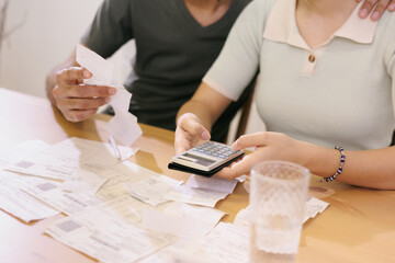 man and woman couple pay electricity and rent bills. African American young married person in...