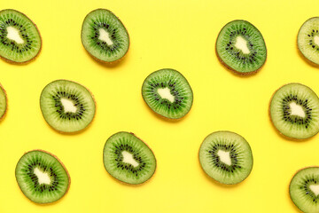 Fototapeta premium Slices of fresh kiwi on yellow background