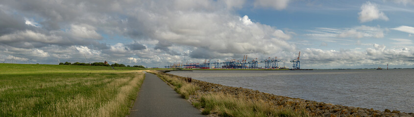 Long bike path along the River Weser in Bremerhaven, in the style of german marine scenes, majestic ports, atmospheric clouds, Beautiful Panorama, travel vibes