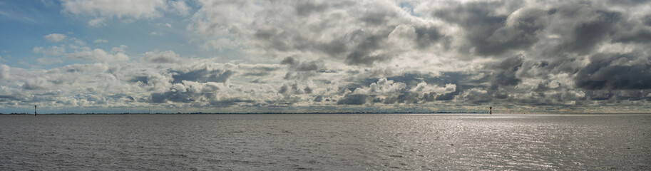 Clouds in the sky over the ocean near Bremerhaven in Germany, North Sea Panorama, Storm on the Ocean, travel vibes, oceanic skyline view, big dark clouds over the water