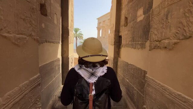 Woman walking touards Trajan's Kiosk or the Pharaoh's Bed on the Philae Temple in Aswan, Egypt