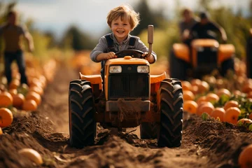 Selbstklebende Fototapete Traktor european boy riding a tractor on pumpkin patch farm autumn fall halloween
