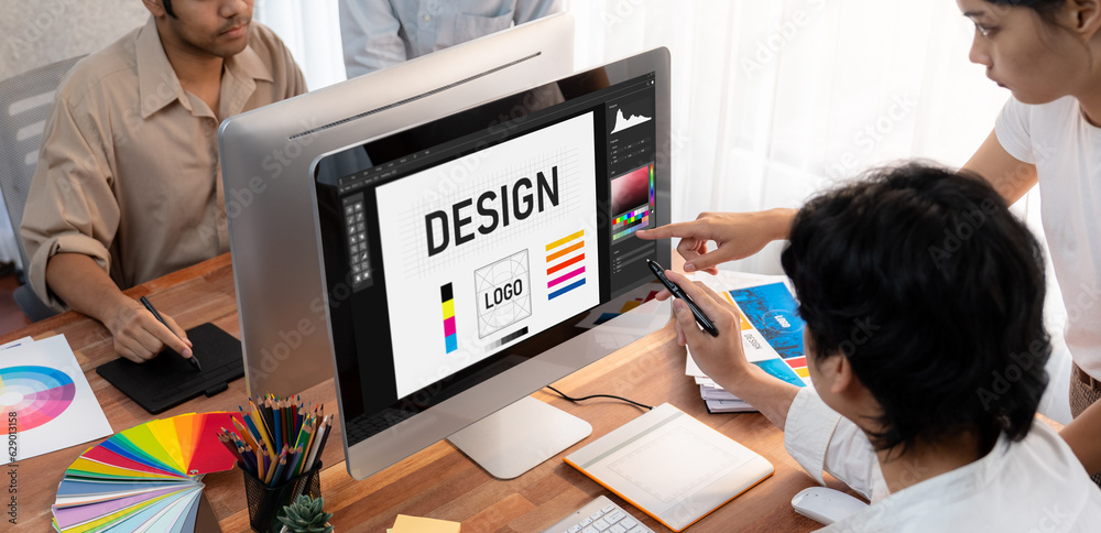 Aufkleber Graphic designer work on computer laptop and with graphic drawing pen while brainstorming unique design with professional graphic team in modern digital studio workplace. Panorama shot. Scrutinize