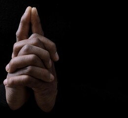 man praying to god with hands together on grey black background stock image stock photo	