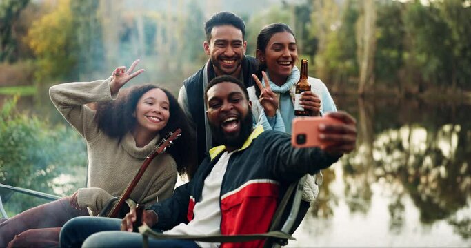 Selfie, bonfire and friends with beer for camping or a celebration and to update social media of a vacation together. Drinks, travel and group of people happy for a picture in the woods or lake
