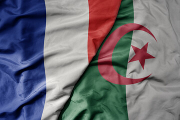 big waving realistic national colorful flag of france and national flag of algeria .