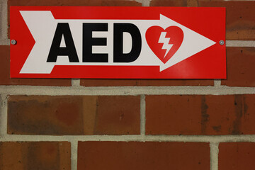 Automated External Defibrillator sign on red brick wall