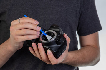 Technician cleaning digital camera sensor. Camera sensor cleaning service.