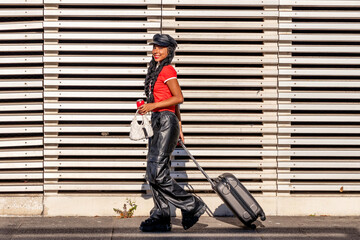 young girl walking with suitcase or luggage on the street