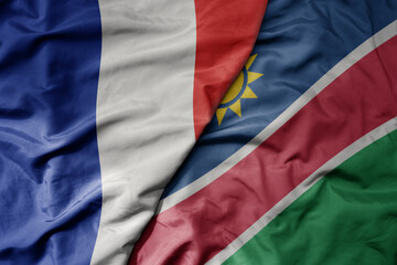 big waving realistic national colorful flag of france and national flag of namibia .