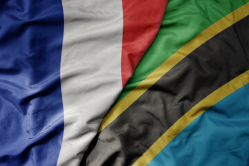 big waving realistic national colorful flag of france and national flag of tanzania .
