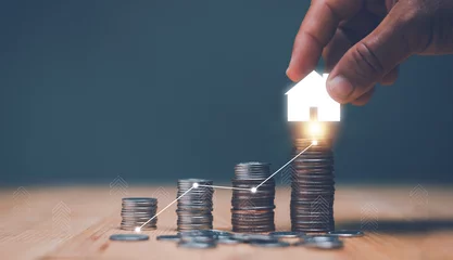 Foto op Plexiglas Investment for real estate concept, Businessman's hand putting house icon on top of coins stack and progressing graph, Savings money for buy house, budgeting, investment for the future. © krungchingpixs