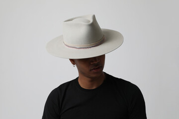 Studio portrait of handsome dark-skinned young man wearing trendy hat. Isolated.