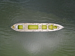 Destroyed abandoned sunk boat on a shallow lake, top-down view