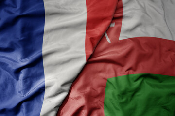 big waving realistic national colorful flag of france and national flag of oman .