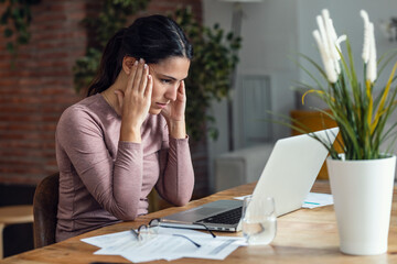 Beautiful young woman with headache while working with pc