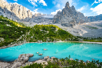Beautiful view on turquoise Sorapis lake and with dito di dio in the background in the evening. Lake Sorapis, Dolomites, Belluno, Italy, Europe.