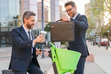 Fototapeta premium Two businessmen discussing outdoor during business meeting. Businessmen talking. Brainstorm with serious colleague. Confident business partners walking on street talking. Business ideas and opinions.