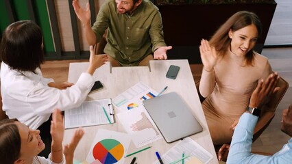 Multinational office workers discuss documents at meeting