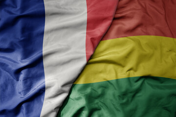 big waving realistic national colorful flag of france and national flag of bolivia .