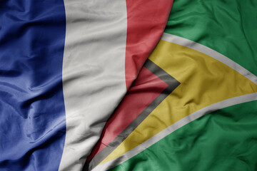 big waving realistic national colorful flag of france and national flag of guyana .