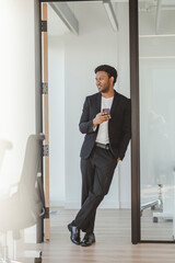 Young african american handsome man using mobile phone, looking away