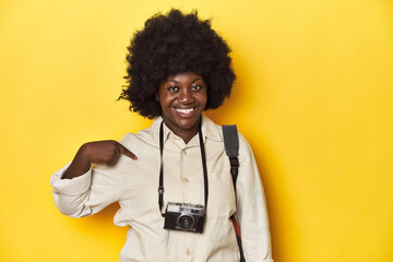 Stylish African-American woman with vintage camera Stylish African-American woman with vintage camera.person pointing by hand to a shirt copy space, proud and confident