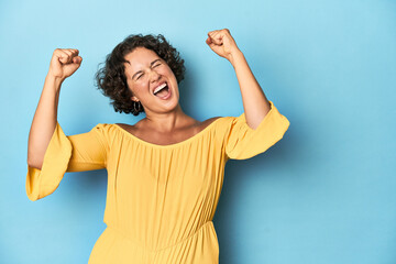 Young Caucasian woman with short hair raising fist after a victory, winner concept.