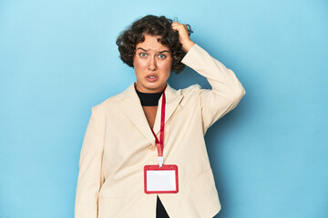 Young woman holding identification card for event being shocked, she has remembered important...