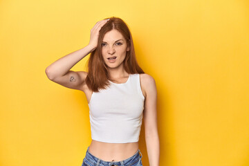 Naklejka premium Redhead in white tank top, relaxed studio pose being shocked, she has remembered important meeting.