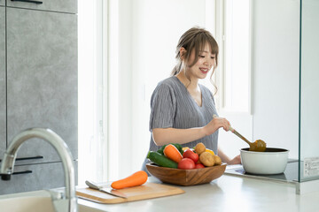 キッチンでカレーを作るアジア人女性・妊婦・プレママ
