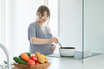 キッチンで料理をするアジア人女性・妊婦・プレママ
