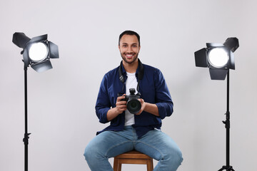 Young professional photographer with camera in modern photo studio - Powered by Adobe