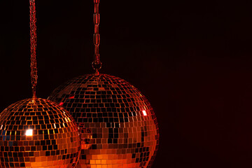 Obraz premium Shiny bright disco balls under red light, space for text