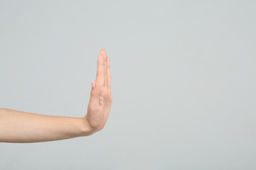 Woman showing stop gesture on light grey background, closeup. Space for text