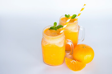 Orange smoothies yellow colorful fruit juice milkshake blend beverage healthy high protein the taste yummy In glass,drink to lose weight drink episode morning on white gray background.