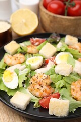 Delicious Caesar salad with shrimps on table, closeup