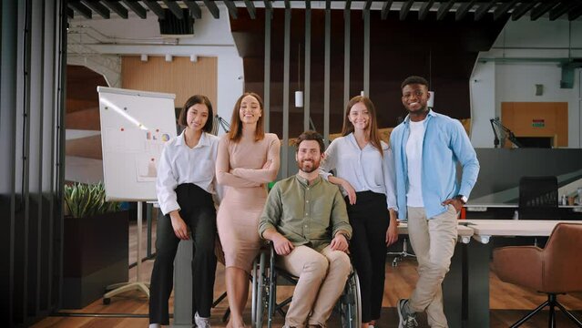 Smiling employees of international company stand in office
