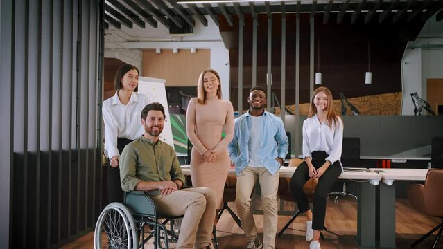 Multiracial group of workers smile happily at workspace