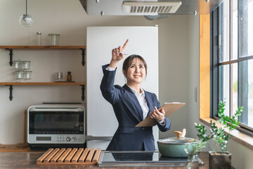 キッチンの換気扇をチェックするアジア人ビジネスウーマン
