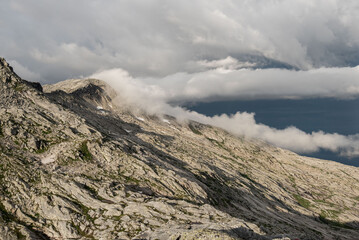 View of Breitinden and Tortenviktinden from smaltinden, Melöy, Norway during a summer thunderstorm. Hiking in Helgeland. Topptur norska fjell. Fjelltur. Dramatic mountain weather. Peak in clouds. 