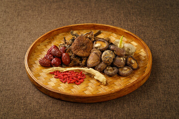 Variety of dried mountain delicacies placed in a bamboo woven tray on a monochrome background