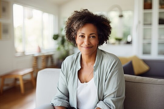 Psychological portrait of a peaceful middle-aged African American woman. She sits at home in a comfortable position. She is confident and happy.