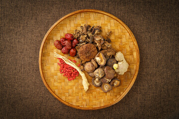 Variety of dried mountain delicacies placed in a bamboo woven tray on a monochrome background