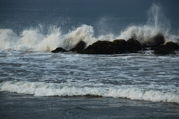 the waves of the sea crashing on the rocks, off the shore