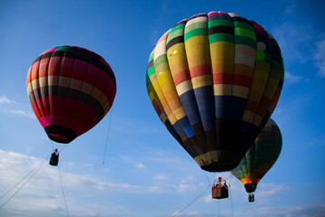 three colorful hot air balloons, darning the blue sky - obrazy, fototapety, plakaty